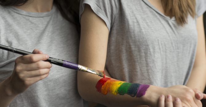 close-up-young-woman-painting-lbgt-flag-her-girlfriend-s-hand-with-paintbrush