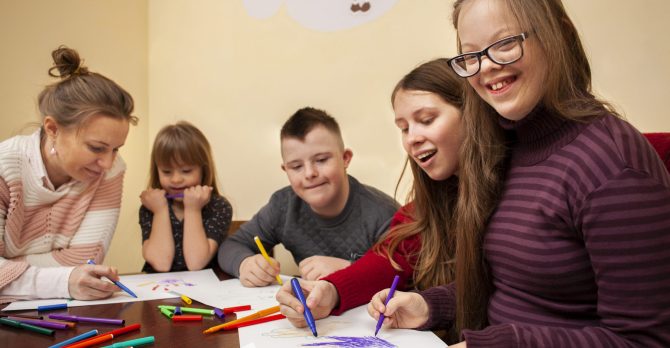 happy-girl-with-down-syndrome-posing-while-drawing